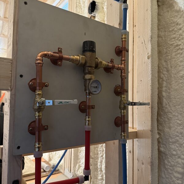 Copper and PEX thermostatic mixing valve panel during a new-construction rough-in