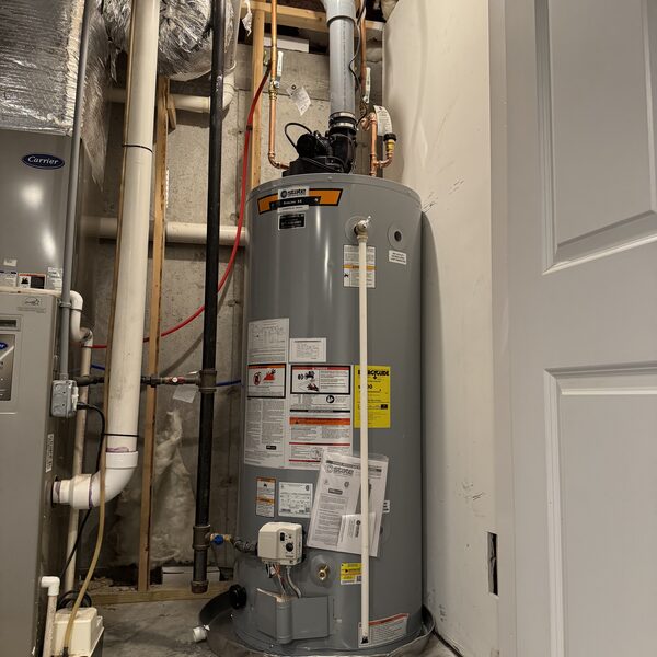 Gas water heater installed in a utility closet beside the furnace
